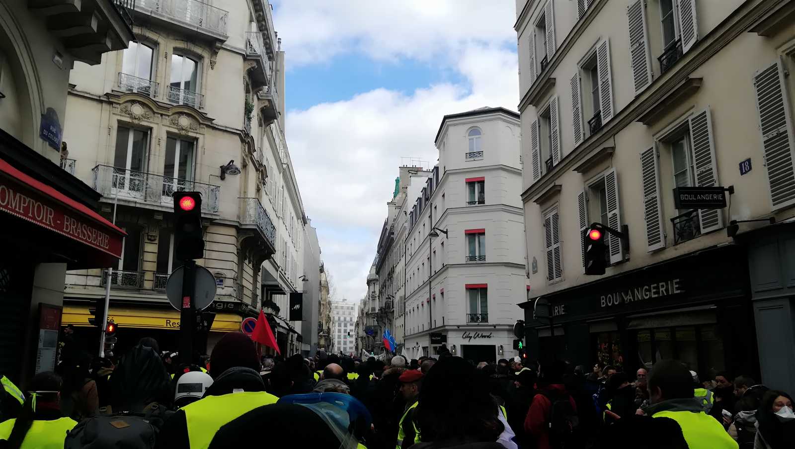 Protesters of the Gilets Jaunes movement are walking in a street of Paris.
