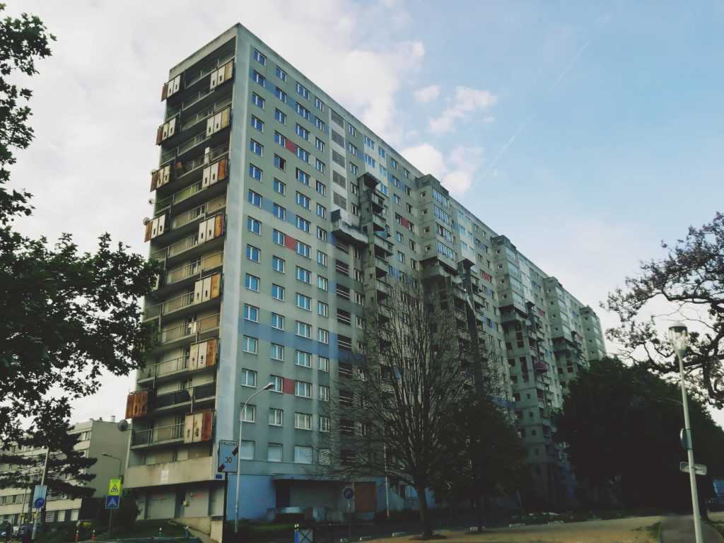A huge social housing building with 15 floors can be seen on the image. Made of concrete and built while brutalism-architecturean era, it is still populated. From the outside the building gives a derelict image. Situated in the banlieue (suburb) of 