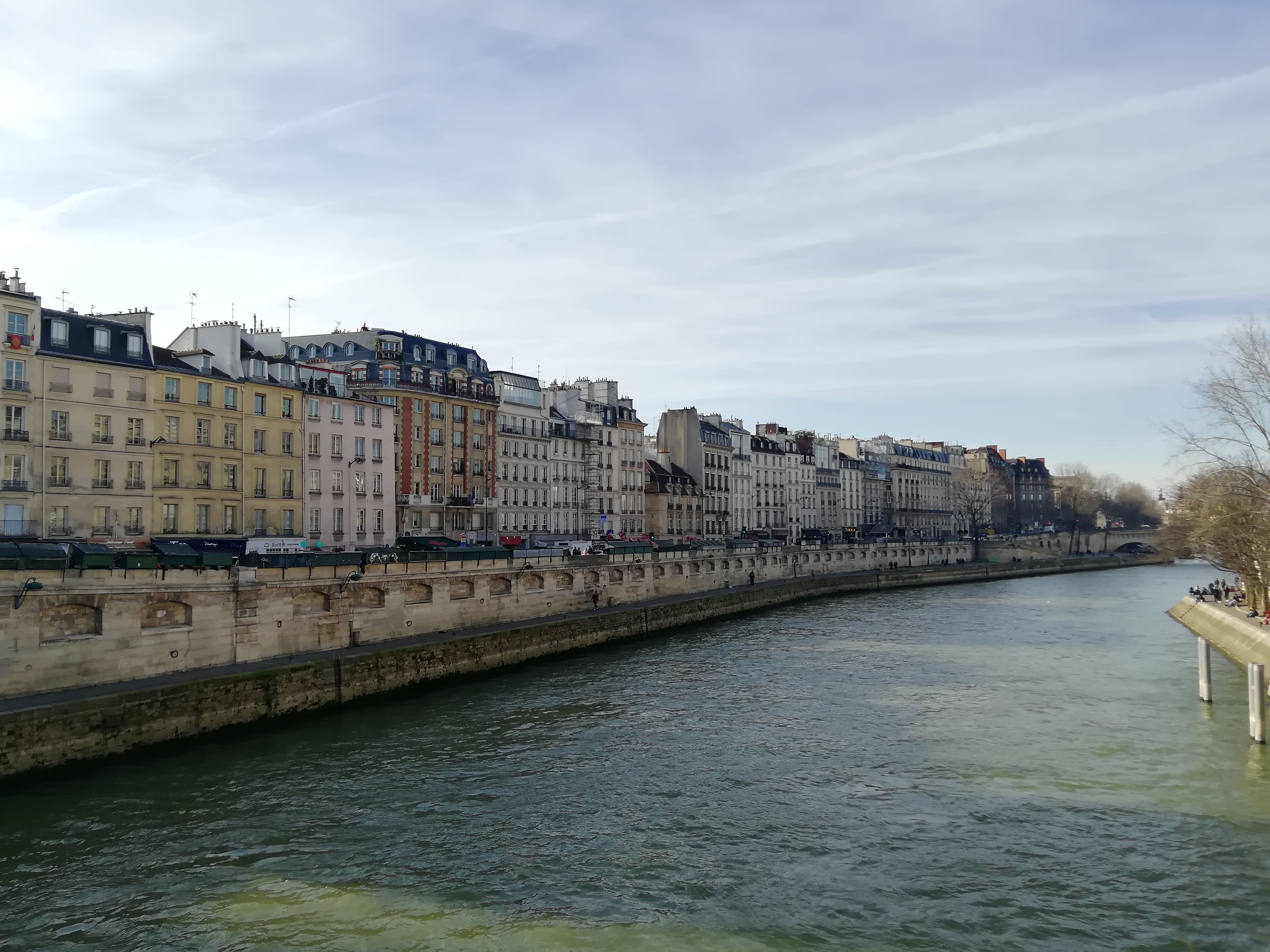 Fluss Seine Paris Frankreich, Flusswehr mit Haussmannischen Fassaden, Herbstwetter ohne Wolken, Wasserfarbe grün bis dunkelgrün bei Schatten.