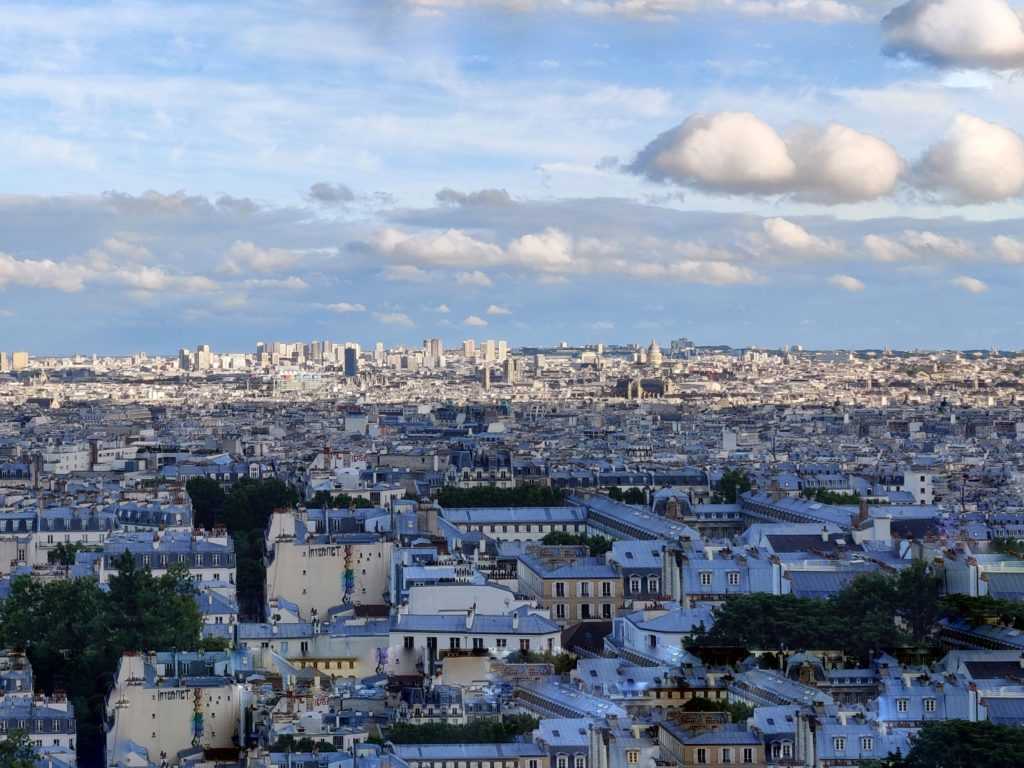 Stadtlandschaft von Paris, grau-silberne Häuserdächer, bewäktes Wetter, endlose Urbanisierung bis zum Horizont