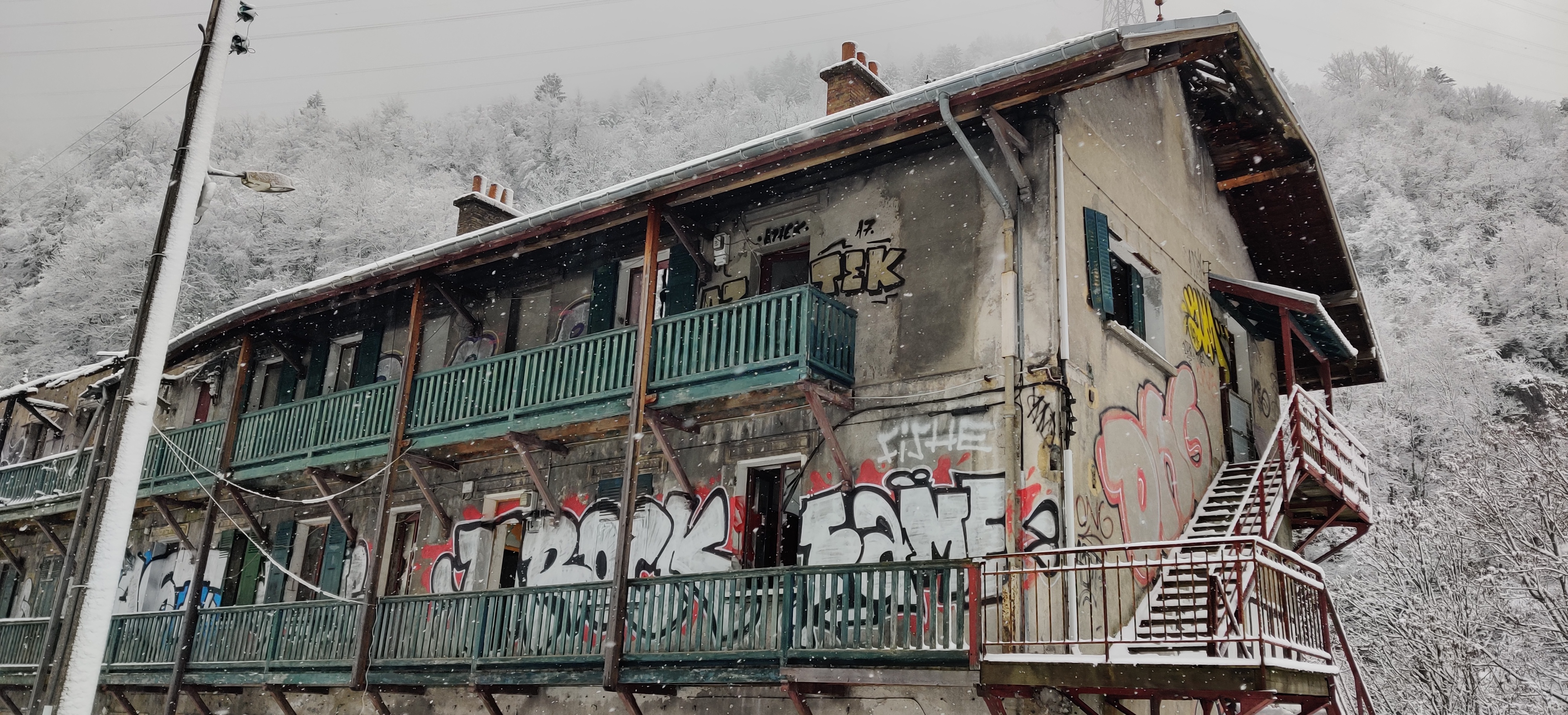 Urbex Frankreich Industriekultur Oisans
Verlassenes Wohnhaus für Arbeiter in den Fabriken. Graffiti Hausfassade eingestürzte Dachstühle, Graffitisprüher: Rock-Fame (Chrom-rot), Atzek (gelb), ONG (chrom-verblasst, rote Outlines), YUM (gelb), Winter, Schnee, Schneeflocken, Alpen, Urban Exploration